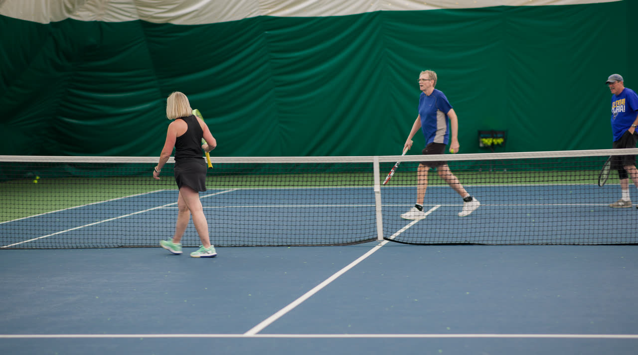 Adults playing doubles on an indoor court at Match Point KC