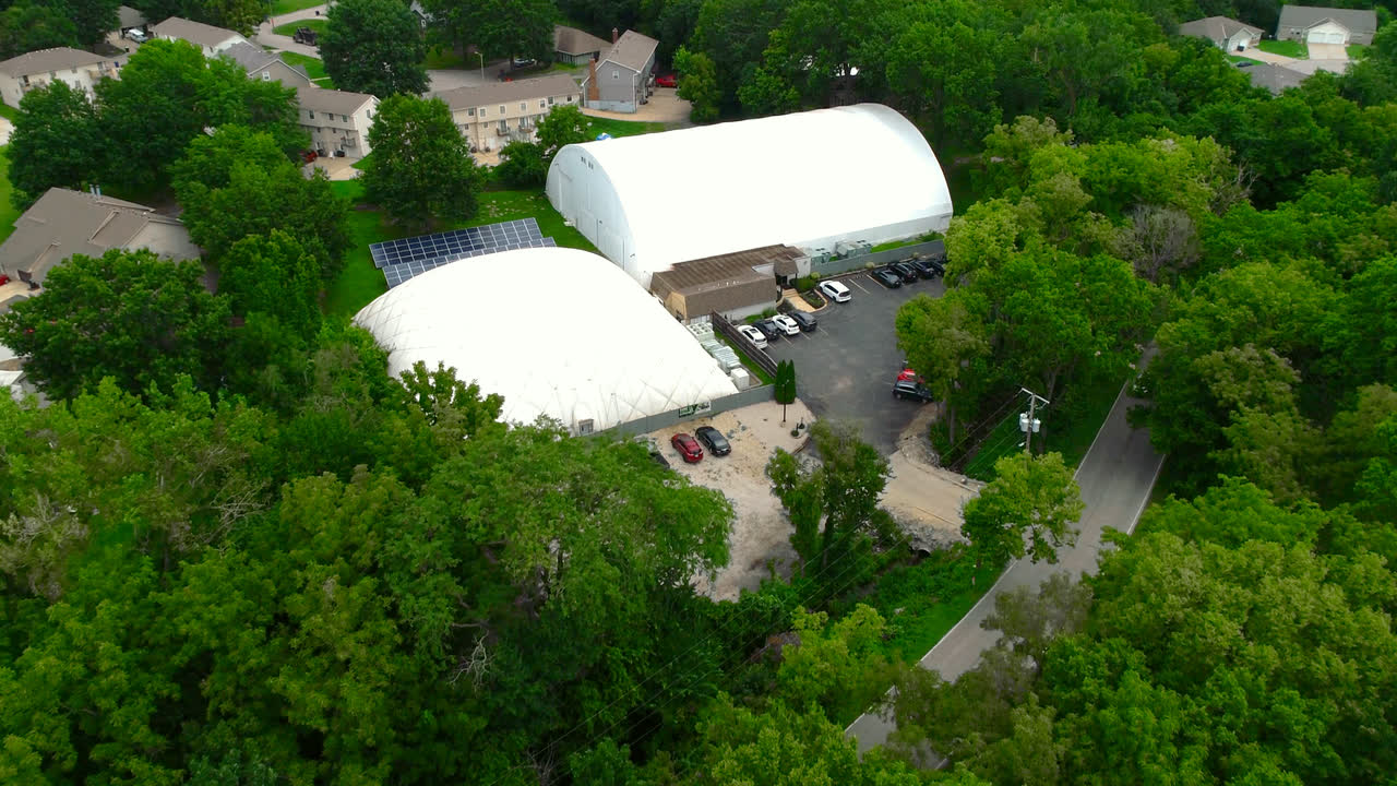 Aerial view of the Match Point KC domes and parking lot among the trees in Blue Springs