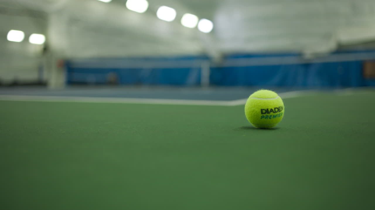 A tennis ball resting on an indoor court at Match Point KC