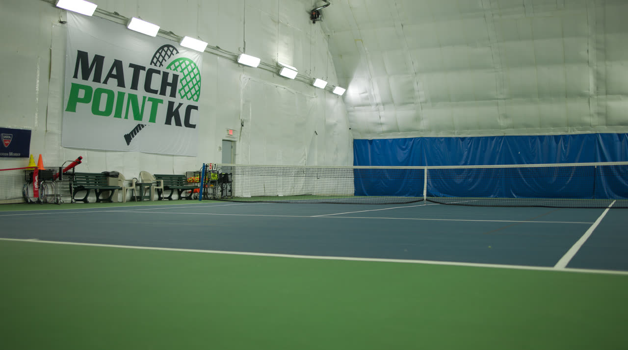 An indoor hard court beneath the Match Point KC banner
