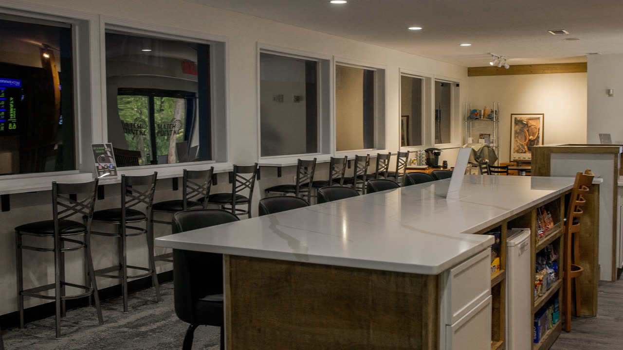 Bar seating along the court-view windows in the lounge at Match Point KC