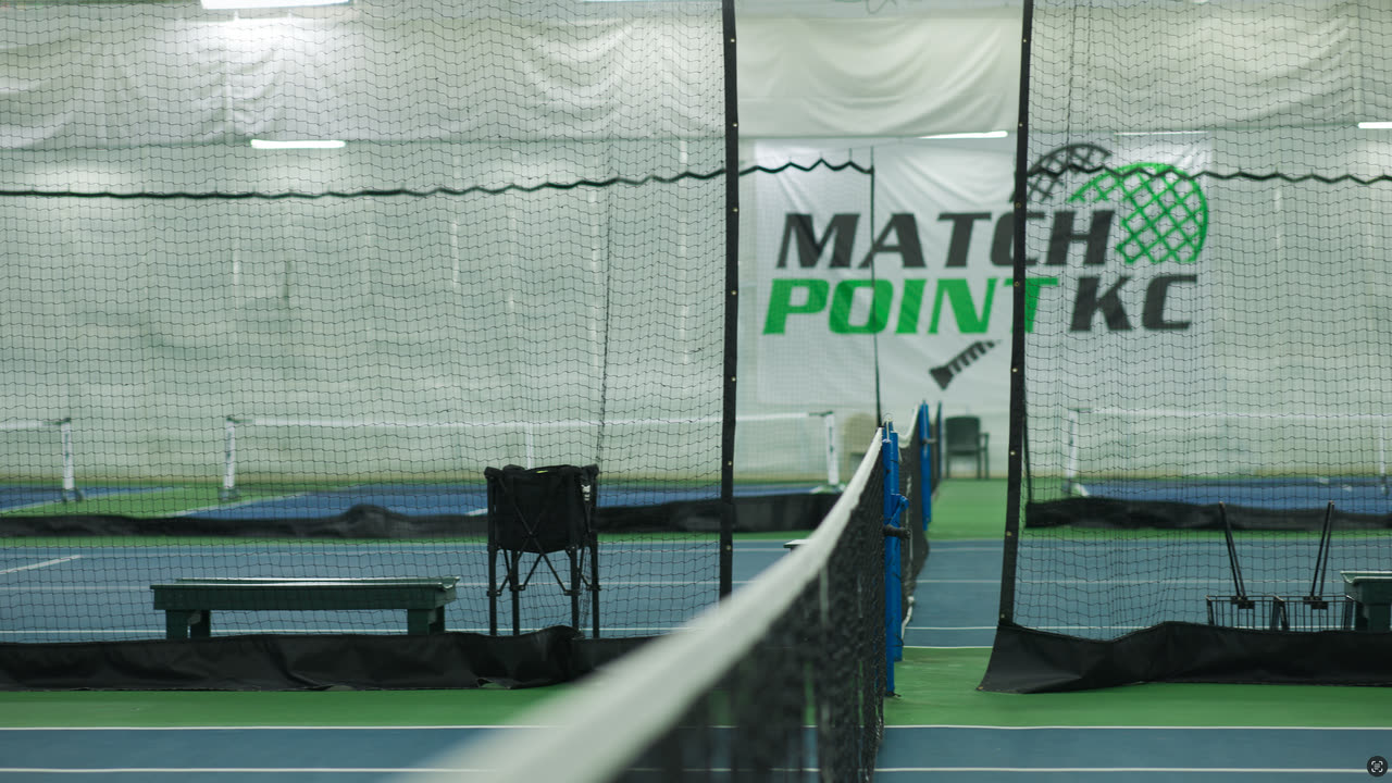 The net line and Match Point KC banner on an indoor court