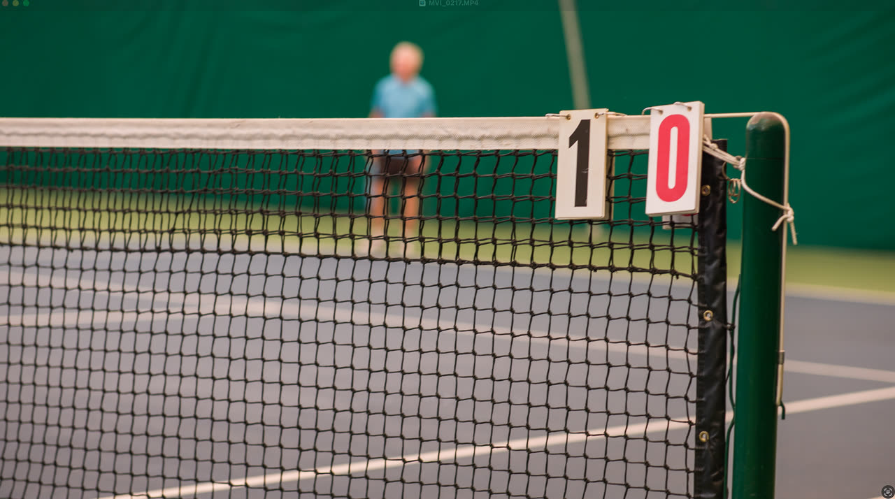 A courtside scoreboard hanging on the net at Match Point KC