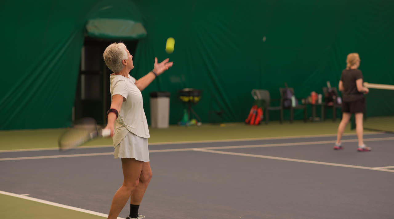 A player serving during a women's session at Match Point KC